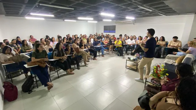 Erikson Oliveira falando para uma sala cheia de estudantes e profissionais de saúde mental